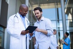 Doctor and patient having discussion on digital tablet